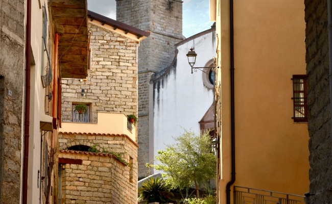 Olzai, schmale Straße im historischen Zentrum und Kirche San Giovanni Battista