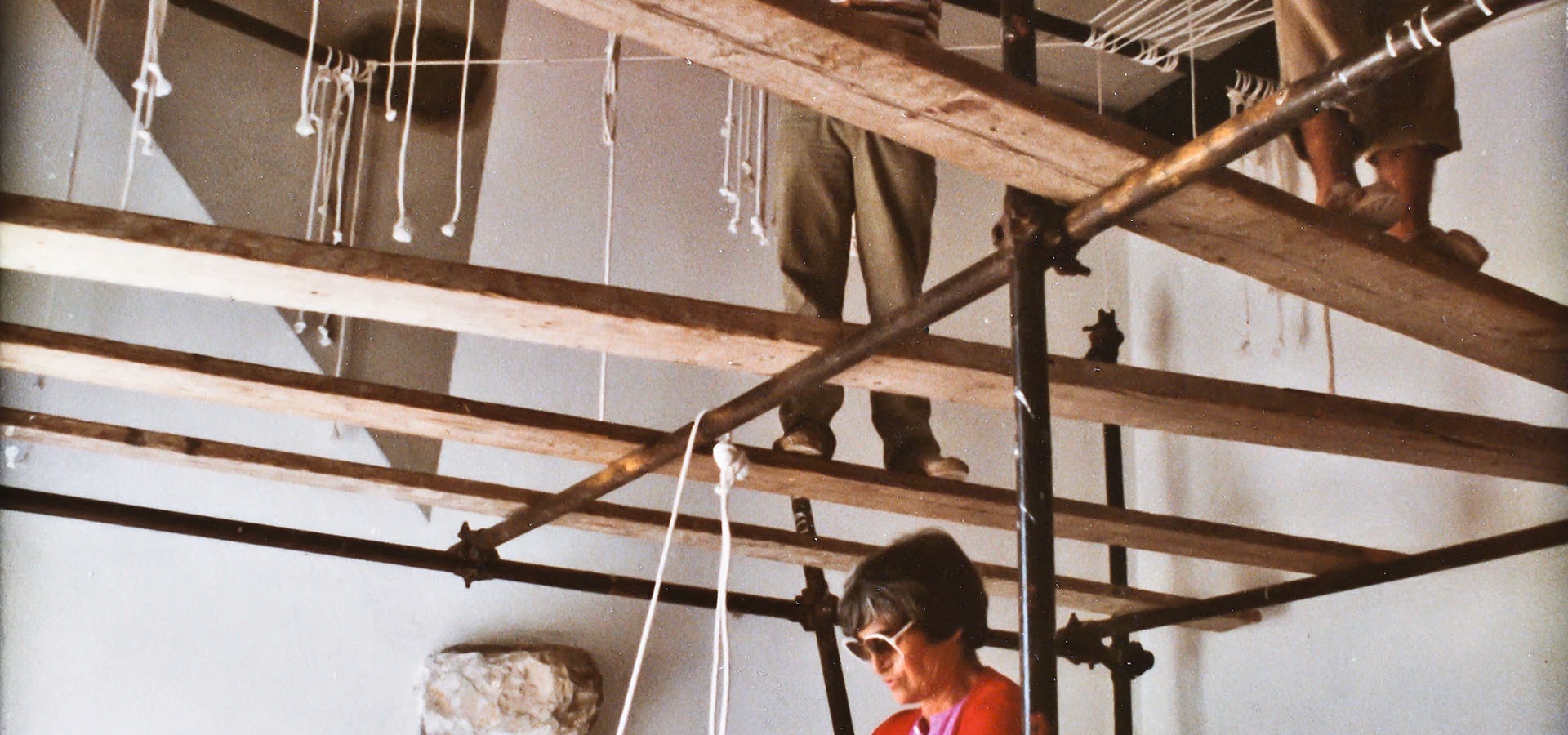 Maria Lai bei der Arbeit während der Montage des Deckenrahmens im Ulassai-Waschhaus, 1982
